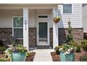 Close up view of home's entry way featuring flower pots, hanging planters and an inviting door at 5832 Buskirk Dr, Indianapolis, IN 46216