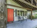 Welcoming front porch with seating, an orange front door, and charming architectural details at 6019 S Tacoma Ave, Indianapolis, IN 46227