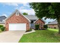 Charming brick home with lush front lawn and a welcoming blue-accented front door at 662 Leah Way, Greenwood, IN 46142