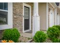 Detailed view of the front door, enhanced by stylish stonework and manicured shrubbery at 7147 Prelude Rd, Brownsburg, IN 46112