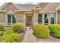 Close up on the front door of this home with a brick facade and manicured hedges at 7304 E Stop 11 Rd, Indianapolis, IN 46259