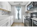Bright kitchen boasts white cabinets, granite countertops, and stainless steel appliances at 7468 Countrybrook Dr, Indianapolis, IN 46260