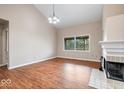 Bright living room featuring wood flooring, a white fireplace, and large windows for natural light at 8213 Thoroughbred Run, Indianapolis, IN 46256