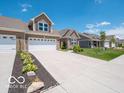A row of homes with well-manicured lawns and inviting driveways provide a picturesque neighborhood setting at 8866 Twain Ln, Indianapolis, IN 46239