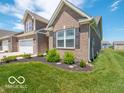 Brick-accented townhome featuring manicured landscaping, adding to its curb appeal at 8866 Twain Ln, Indianapolis, IN 46239