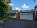 A well-maintained single-story home featuring a blue metal roof and a two-car attached garage at 8923 Maze Rd, Indianapolis, IN 46259
