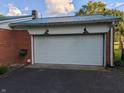 A spacious two-car garage featuring a newly painted white garage door and outdoor lighting at 8923 Maze Rd, Indianapolis, IN 46259