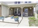Inviting front porch with hanging flower baskets, potted plants, and seating area on decorative white stones at 9628 Gull Lake Dr, Indianapolis, IN 46239