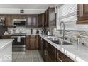 Updated kitchen featuring stainless steel appliances, marble countertops, mosaic tile backsplash, and dark wood cabinets at 9628 Gull Lake Dr, Indianapolis, IN 46239