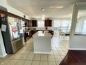 Open kitchen features dark wood cabinets, stainless steel appliances, a kitchen island, and breakfast dining area at 9628 Gull Lake Dr, Indianapolis, IN 46239