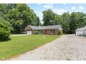 A charming brick home with a long driveway and a lush, green front yard under a blue sky at 10519 N Antioch Rd, Mooresville, IN 46158