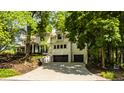 Spacious two-car garage with ample parking, framed by a lush green lawn and mature trees for privacy at 110 Bow Ln, Indianapolis, IN 46220