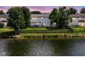 A well-maintained backyard with a wooden fence, overlooking a peaceful pond at twilight at 11820 Stepping Stone Dr, Fishers, IN 46037