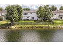 A well-maintained backyard with a wooden fence, overlooking a peaceful pond on a sunny day at 11820 Stepping Stone Dr, Fishers, IN 46037