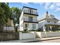 Modern three-story home with white siding, black trim, and a double-balcony facade offers stylish curb appeal at 1405 E Vermont St, Indianapolis, IN 46201
