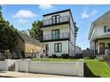 Modern three-story home with white siding, black trim, and a double-balcony facade offers stylish curb appeal at 1405 E Vermont St, Indianapolis, IN 46201