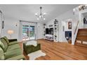 Bright living room with hardwood floors, chandelier lighting, a sliding glass door, and modern decor at 1481 Wrenwood Dr, Columbus, IN 47201