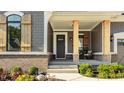 Inviting front porch with wooden pillars, brick accents, and a cozy seating area at 15600 Woodford Dr, Westfield, IN 46074