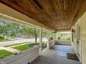 View of the covered front porch with wood ceiling and brick detailing at 1602 California St, Columbus, IN 47201