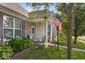 Inviting front porch with seating, well-maintained lawn and an American flag at 2017 Shadow Creek Blvd, Columbus, IN 47201