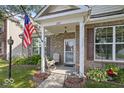 Attractive brick home with rocking chairs on the covered front porch and tidy landscaping at 2017 Shadow Creek Blvd, Columbus, IN 47201