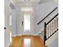 Bright foyer featuring hardwood floors, stairs, and a frosted glass front door allowing plenty of natural light at 2263 Glebe St, Carmel, IN 46032