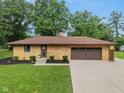 Well-maintained brick ranch with attached garage, lush lawn and landscaping, and modern features at 2750 Chamberlin Dr, Indianapolis, IN 46227