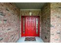 Stunning red front door framed by brick with sidelights, perfect for curb appeal at 35 Decourcy Ln, Franklin, IN 46131