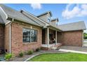 Close up of brick home showcasing the front porch, front door, and landscaping at 35 Decourcy Ln, Franklin, IN 46131