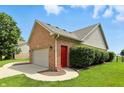 Two car detached garage featuring painted door, brick siding, and side entry door at 35 Decourcy Ln, Franklin, IN 46131