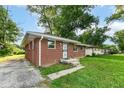 Brick home featuring a well-maintained exterior and a driveway leading to the side of the property at 3938 N Grand Ave, Indianapolis, IN 46226