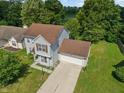 Aerial view of a charming home surrounded by lush trees and manicured lawns on a bright, sunny day at 4533 Golden Meadow Dr, Indianapolis, IN 46254