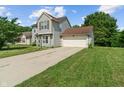 Two-story home with an attached garage, a well-manicured lawn, and a long driveway under a sunny sky at 4533 Golden Meadow Dr, Indianapolis, IN 46254
