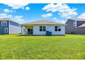 Spacious backyard with green grass, offering a serene outdoor setting with a covered patio at 5120 Woodhurst Ln, Indianapolis, IN 46239