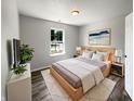 Cozy bedroom with a large window, stylish decor, wood-look floors, and ample natural light at 5210 Sandy Forge Dr, Indianapolis, IN 46221