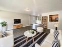 Bright living room with sleek tile floors, built-in shelving, and neutral decor at 5210 Sandy Forge Dr, Indianapolis, IN 46221