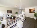 Bright living room featuring stylish decor, a striped rug, comfortable seating, and a view into the kitchen at 5210 Sandy Forge Dr, Indianapolis, IN 46221