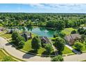 Beautiful aerial view of a neighborhood featuring a serene pond at 5761 Coopers Hawk Dr, Carmel, IN 46033
