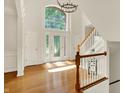 Bright foyer boasts hardwood floors, a grand staircase, and a large window at 5761 Coopers Hawk Dr, Carmel, IN 46033