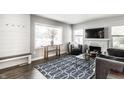 Bright living room with a stone fireplace, large window, and a geometric patterned area rug at 6491 N Oxford St, Indianapolis, IN 46220