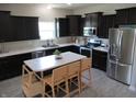 Well lit kitchen with stainless appliances, dark cabinets, and an island with seating at 7232 Moultrie Dr, Indianapolis, IN 46217
