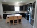Modern kitchen with stainless appliances, dark cabinets, an island and seating for entertaining at 7232 Moultrie Dr, Indianapolis, IN 46217
