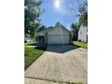Traditional one-story home with a long driveway and well-maintained front lawn on a sunny day at 8323 Lake Tree Ln, Indianapolis, IN 46217