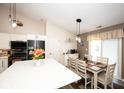 Kitchen and dining area with wood floors, white cabinets, and modern appliances at 8514 Midsummer Dr, Indianapolis, IN 46239