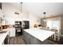 Updated kitchen features white cabinets, black appliances, mosaic backsplash, and center island at 8514 Midsummer Dr, Indianapolis, IN 46239