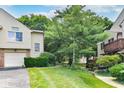 This home has a beautiful exterior with a lush lawn, mature trees, and a well-manicured landscape at 9552 Maple Way, Indianapolis, IN 46268