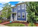 Charming two-story home with blue siding, white trim, a welcoming porch, and beautifully landscaped front yard at 12874 Tradd St, Carmel, IN 46032