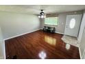 An empty living room featuring hardwood floors, a ceiling fan, and an exterior door at 1345 S Biltmore Ave, Indianapolis, IN 46241