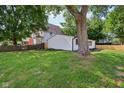 Expansive back yard featuring lush green grass, a classic tree, and new wooden fences at 1648 Ringgold Ave, Indianapolis, IN 46203