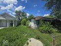 Exterior view of a neglected home with overgrown yard showing peeling paint and lack of curb appeal at 1816 E Highland Ave, Muncie, IN 47303